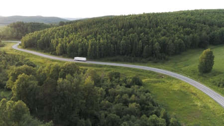 Panorama with truck driving on highway in summer. Action. Beautiful summer landscape with green trees and truck driving along highway. Truck is driving on country highway on summer dayの写真素材