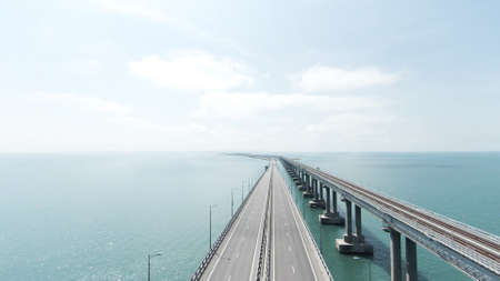 Top view of long bridge highway across sea. Action. Beautiful landscape with hinged white bridge...