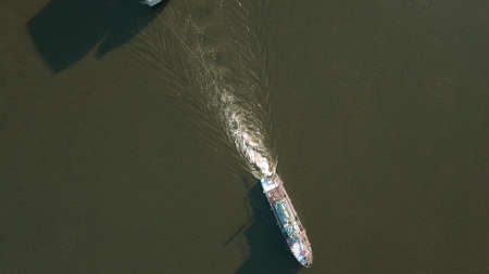 Winter birds-eye view. Clip. Cargo ships moving along the river and carrying cargo .