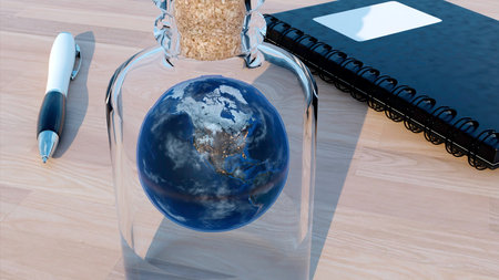 Rotating Earth globe inside glass bottle. Design. Surreal illustration of the planet on the table, notebook and a pen.の写真素材