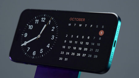 Close-up of clock on phone. Action. Stylish design of touch screen saver on charging station. Clock...