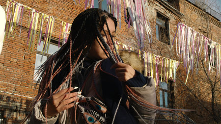 Woman with dreadlocks on street. Stock footage. Beautiful young woman with multicolored pigtails....