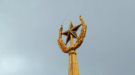 Soviet symbol, golden spire on a cloudy sky background. Stock footage. Golden star and ears of wheat.の写真素材