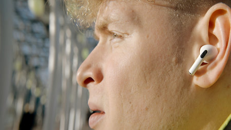 Close-up of young man singing along to music with headphones. Action. Young man in wireless...