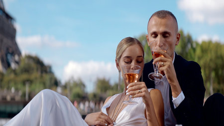 Flirting people on a date. Action. A happy young couple in beautiful clothes drinking champagne on the street.の写真素材
