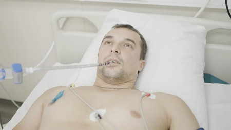 In the operating room. Action. A man lying in a hospital who is looking at an X-ray of a heartbeat...