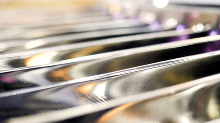 Close up of metal blurred parallel bars with blinking small light bulbs. Media. Industrial background with a part of machine.の写真素材