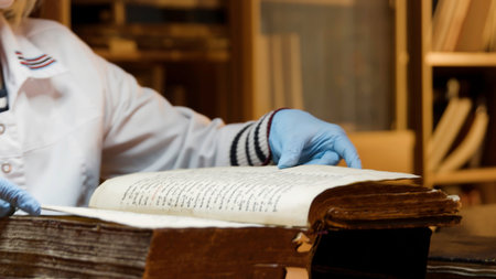 The master is restoring an old book. Stock footage. Close up of a book restorer hands turning pages slowly.の写真素材