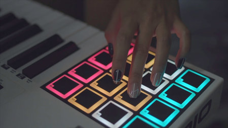 Drum machine in the night club playing live set. Stock. Fingers tapping drum pads on a digital...