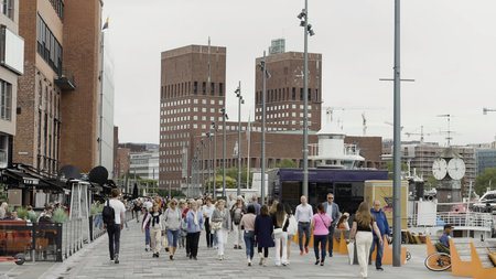 Norway, Oslo - July 27, 2022: crowded city street on a summer day. Action. People walking along buildings.のeditorial素材