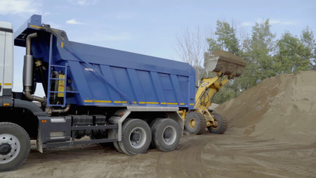Berlin, Germany - June 20, 2022: Different machines work at a stone quarry. Scene. Industrial background with tractors and trucks loading stones and sand.のeditorial素材