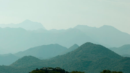 Spectacular morning fog in the mountains above its peaks. Creative. Mist in green mountain forest, morning haze and breathtaking hillsの写真素材