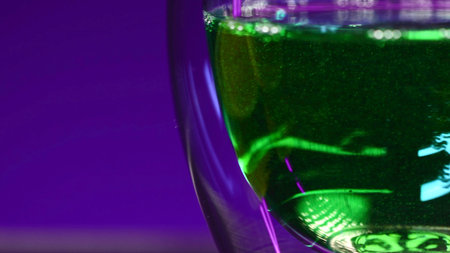 Close-up of green drink in glass. Stock clip. Bright green drink with alcohol in night bar. Alcoholic beverages in bars and clubs.の写真素材