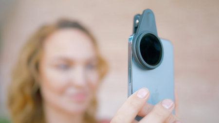 USA, San Francisco - June 9, 2022: Close-up of iPhone with lens. Action. Woman takes pictures on...