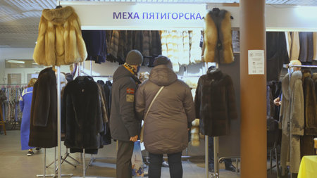 YEKATERINBURG, RUSSIA - FEBRUARY 25, 2022: People go to the fair. ART. A woman in dress walks through the market. many people buy and sell things to each other at the festivalのeditorial素材