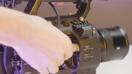 Japan, Tokyo - June 9, 2022: Close-up of cable connection to video camera. Action. Manual video...