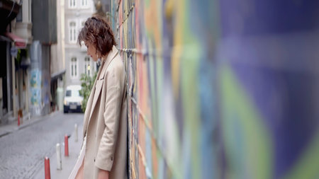 Beautiful portraits next to the graffiti wall. Action.Stylish people participating in street art shooting with a wall with bright graffiti.の写真素材