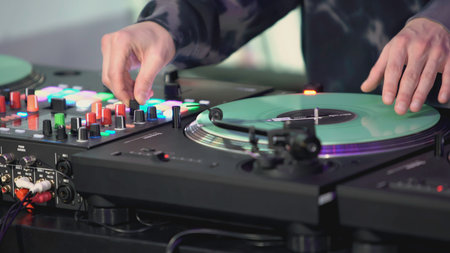 DJs hands on the mixing console close-up. ART. The DJ is playing a musical set. The guy plays with his left hand on the soundboard of the DJ consoleの写真素材