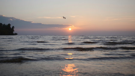 Beautiful landscape with small waves with sea sunset. Creative. Waves in shallow water with setting sun on horizon. View from beach to beautiful sunset with small wavesの写真素材