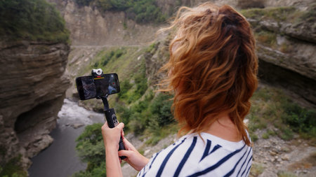 Woman taking video of beautiful gorge and river. Action. Concept of travelling.