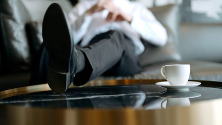 Resting man in a suit. Action.A young businessman who throws his feet on the table with a cup of tea...