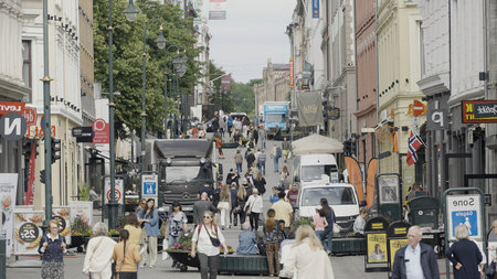 Norway, Oslo - July 27, 2022: crowded city street with many shops and restaurants. Action. Busy...