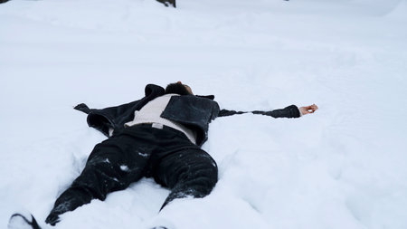 Happy young man in fairytale winter forest lying on snow. Media. Concept of religion and feeling unity with nature.の写真素材