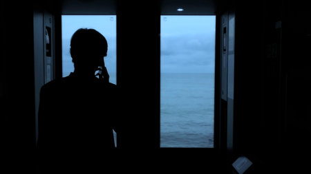 Young man standing next to a train window and looking outside Stock clip. Man with smartphone...