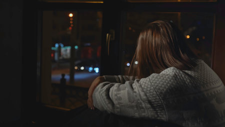 Woman with depression looks out window of house. Media. Woman with anxiety disorder sits on horse and is sad. Woman in sweater sits alone on windowの写真素材