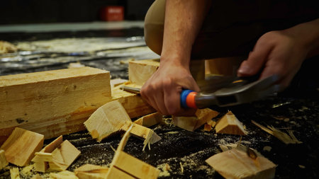 Carpentry works, carving wood block. Media. Using chisel for processing timber bar while assembling stage decorations.の写真素材