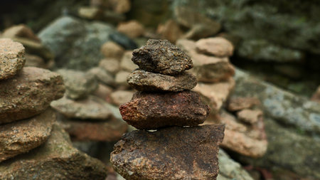 Close-up of stacked towers of stones. Clip. Mountain stones were stacked in turrets. Stacked turrets of rocks on background of rocksの写真素材