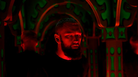 Hipster man dancing and listening to techno music at night club. Media. Interior of neon lighting and lots of mirrors.の写真素材