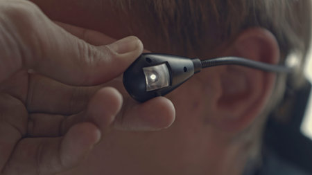 Close-up of flashing earphone. Stock. Man uses special earphone with backlight. Man with earpiece...