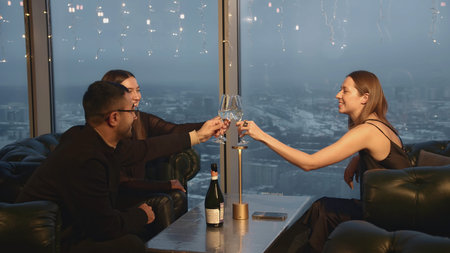 Friends chat and drink champagne in elegant restaurant. Media. Meeting friends with champagne in...