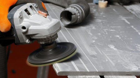 Process of grinding raw wood plank with angle grinder in workshop. Creative. Flying wood dust while...