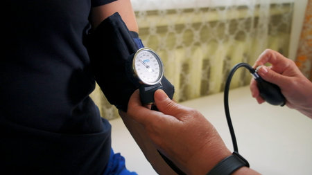 Doctor uses mechanical tonometer to check body pressure of a male patient. Clip. Concept of health...