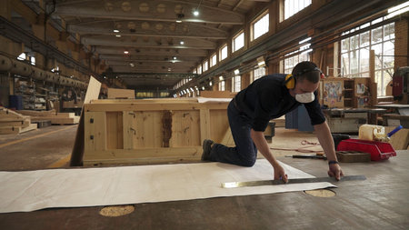 A skilled craftsman is diligently working in a woodworking workshop, creating beautiful pieces. Stock Clipの写真素材