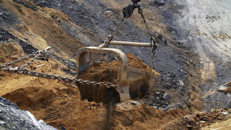Heavy machinery is actively engaged in excavating soil on a bustling construction site. Stock Clip