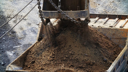An Excavator Bucket is Lifting a Load of Various Soils on a Busy Construction Site. Stock Clipの写真素材