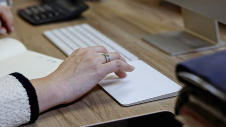 Close up of elegant female hand with a ring on her finger typing on white keyboard. Media.の写真素材