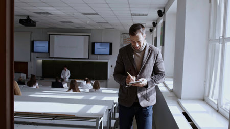 Student leaving the classroom. Stock footage. Young man leaving auditorium during class.の写真素材