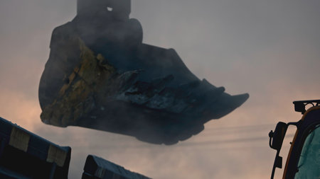 Excavator pours out industrial mined coal. Stock footage. Cinematic shots of coal pouring out of excavator. Mining at quarry in winterの写真素材