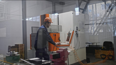 Worker with control panel for automated machines at factory. Stock clip. Specialists in programming...