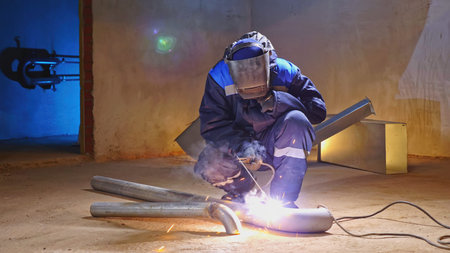 Man with welding at construction site. Clip. Masked man with welding on construction site. Man is...