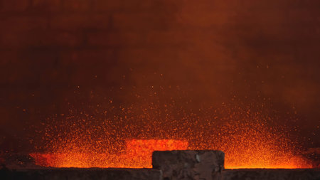 Splashes of red-hot metal at factory. Stock footage. Stream of hot metal splashes at factory....