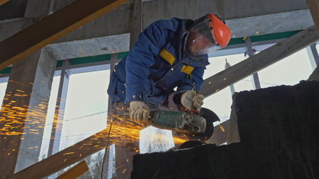 Masked man with sawing jobs at construction site. Clip. Worker in uniform and mask for working with...