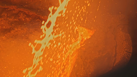 Splashes of molten metal at factory. Stock footage. Bright splashes of molten metal move in streams....