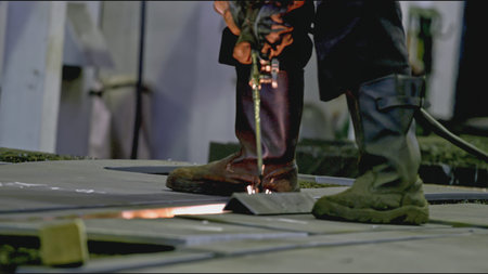 Professional welder at industrial plant. Stock clip. Worker carries out welding work at metalworking plant. Welder makes seams on metal structuresの写真素材