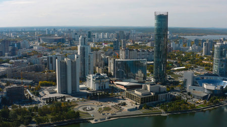 Top view of beautiful modern city with river on sunny day. Stock footage. Beautiful panorama of city with high-rise buildings on sunny summer day. Summer in modern city with skyscrapers and riverの写真素材