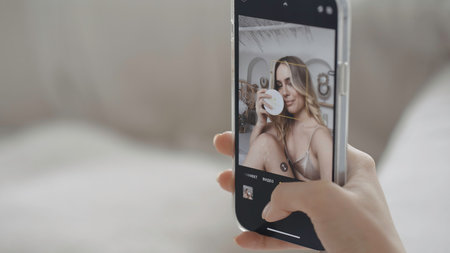 Close-up of beautiful young woman taking selfie. Action. Phone screen with selfie of young woman.の写真素材